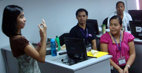 Maricris Siping instructs trainees on fingerspelling.