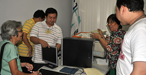 Sir Ervin inspects the computer donated by ADOC.